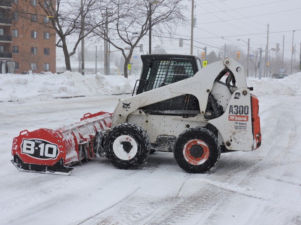 Griffin Bobcat with Plow in Snowy Parking Lot